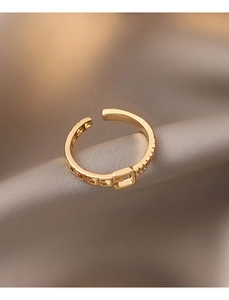 Détail d'une bague boucle de ceinture dorée avec pavé de cristaux et ajourages