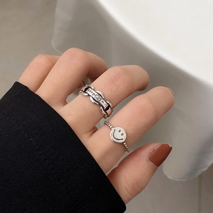 Detailed view of silver smile chain rings with keep smiles engraving on hand
