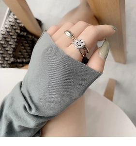 Detail of vintage s925 silver rings with Lucky tag and smiling face on hand