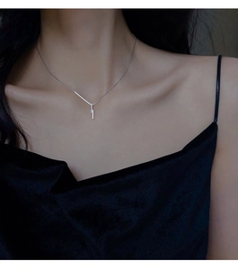 Detail of s925 silver necklace with micro-paved cubic zirconia vertical bar on a model