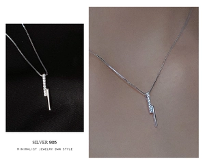 Macro detail of S925 silver bar necklace with pavé stones shown on textured fabric