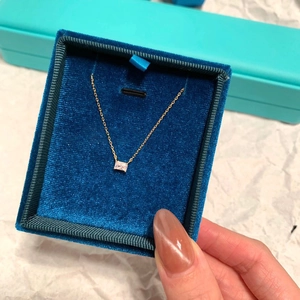 Dettaglio della collana quadrata in cristallo dorato in un astuccio di velluto blu