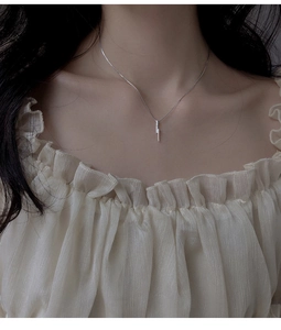 Detail of S925 silver vertical bar necklace with micro-pave zircons on a model