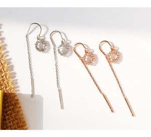 Vue détaillée des boucles d'oreilles pendantes en argent et or rose avec cercles sertis