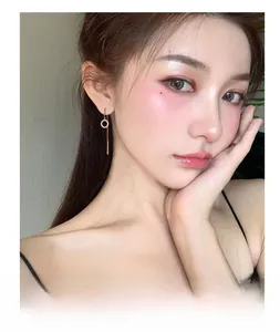 Détail macro d'une élégante boucle d'oreille dorée à pompon sur un mannequin