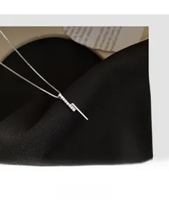 Close-up of a s925 silver bar pendant with pavé set micro-diamonds and box chain necklace