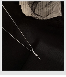 Macro shot of silver S925 necklace with vertical bar pendant and micro-set crystals
