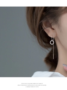 Gros plan sur la boucle d'oreille pompon en argent rose avec cercle de cristal
