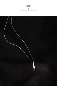 Macro detail of S925 silver vertical bar pendant with micro-set zircon on black fabric