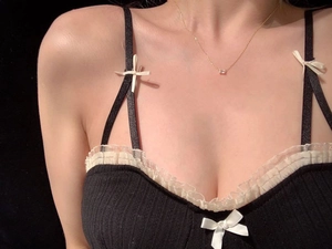 Dettaglio della collana quadrata con cristalli indossata su top in pizzo nero