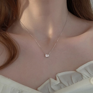Primo piano dell'elegante collana con pendente in zircone quadrato sul collo per uno stile minimal