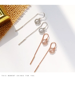 Vue détaillée de boucles d'oreilles pampilles en argent et or rose avec anneaux en zircon