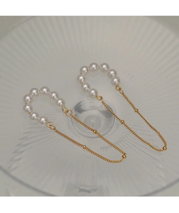 Macro detail of elegant vintage gold tassel earrings with pearls on frosted glass