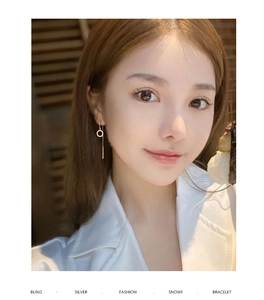 Détail de boucles d'oreilles pendantes en or rose avec cercle scintillant sur un modèle