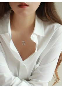 Macro di una collana d'argento con pendente ovale intrecciato sulla clavicola del modello