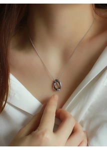 Dettaglio della collana con ciondolo a cerchio Mobius argento indossata sulla clavicola