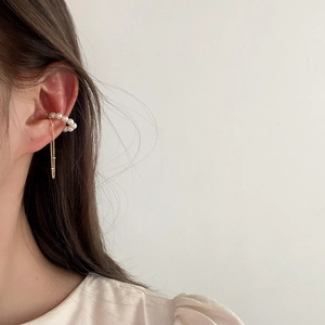 Elegant pearl tassel ear cuff with gold chain fringe worn on a model in a minimal style