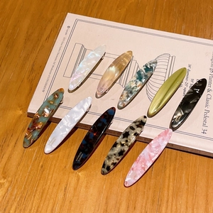 Elegant acetate willow leaf hair clips in ten assorted marble patterns on book pages
