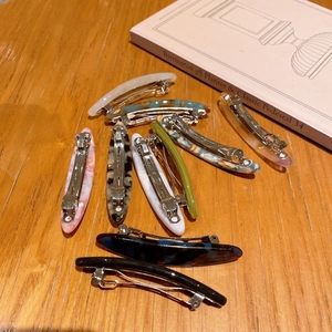Detailed close-up of acetate spring hair clips with marble patterns on a wooden table