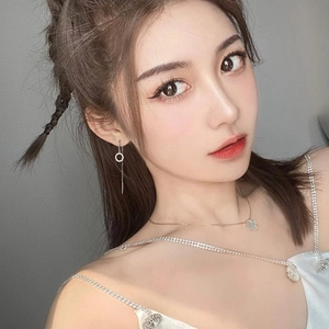 Boucles d'oreilles cercle à pompon en argent sterling et collier trèfle sur un mannequin