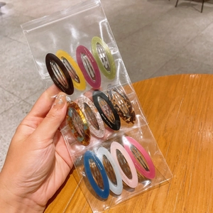 Set of 10 colorful oval acetate hair clips with gold logo in clear packaging