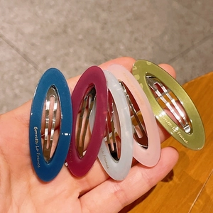 Detailed view of colorful acetate oval hair clips with gold Barrette La France lettering