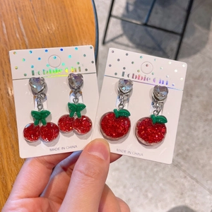 Close-up of resin cherry and apple clip-on earrings with red glitter for girls