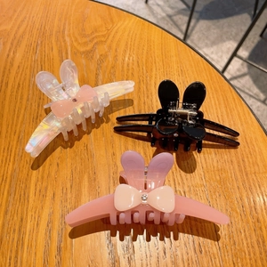 Détails de pinces à cheveux oreilles de lapin avec nœuds sur fond en bois