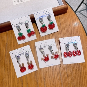 Detail view of five pairs of resin glitter clip-on earrings with cute fruit and bunny shapes