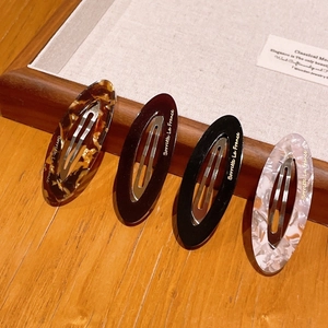 Elegant acetate oval hair clips set in tortoiseshell and marble patterns with gold label