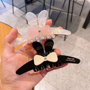 Détail de pinces à cheveux oreilles de lapin avec nœud et cristaux en noir et blanc
