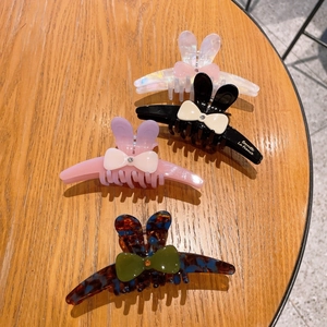 Détail de quatre pinces à cheveux oreilles de lapin avec nœuds et cristaux sur bois