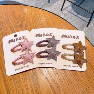 Gros plan de jolies barrettes étoiles en cuir PU pour enfants aux tons rose, violet et brun