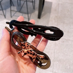 Dettaglio del fermaglio per capelli nero e clip gatto leopardato ambrato
