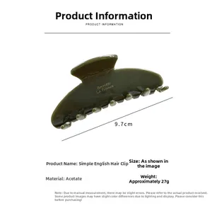Detail view of a 9.7cm dark green acetate shark hair clip with a golden brand logo