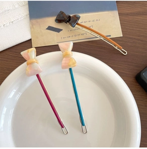 Close-up of three aesthetic bow hair clips with gradient and tortoiseshell patterns