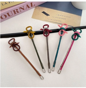 Set of five colorful bow hair clips in autumn tones on a stylish textured lifestyle background