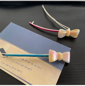Close-up of pink and teal marble resin bow hair clips with metal frog snap fasteners