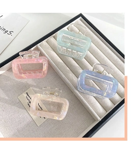 Rectangle acetate hair claws in pearlescent pink, mint, blue, and cream on a tray