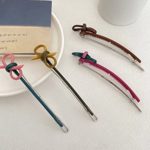 Set of four vintage resin bow hair clips in vibrant colors on a white textured background