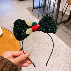 Detail eines grünen Pailletten-Haarreifens mit Pilz-Ornamenten und Goldblatt für Weihnachten