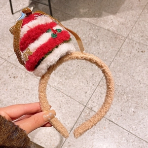Détail d'un serre-tête bonnet de Noël en peluche avec étoile brillante et rayures