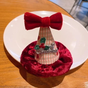 Détail du nœud en velours rouge et de la barrette chapeau de Noël à carreaux festifs