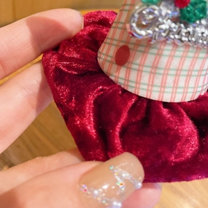 Gros plan d'une barrette de Noël en velours rouge avec motif Merry Christmas