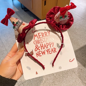 Détail d'un serre-tête de Noël en velours rouge avec mini chapeaux et lettrage métallique