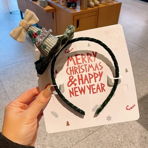 Détail d'un serre-tête de Noël en velours avec chapeau à carreaux et mot de Noël