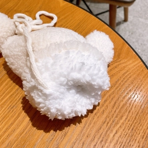 Dettaglio cappello invernale in peluche bianco per bambini con orecchie e coulisse