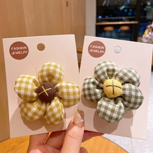 Close-up of cute gingham fabric sunflower hair clips on a display card for girls