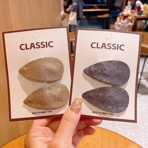 Detail van glitter haarspeldjes in goud en donkergrijs met fonkelende textuur