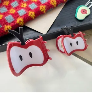 Détail de deux pinces à cheveux en forme de pomme rouge avec yeux de dessin animé